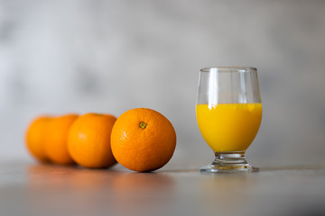 Sok pomarańczowy w szkle i kilka pomarańcz