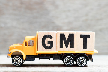 Truck hold letter block in word GMT (abbreviation of Greenwich Mean Time) on wood background