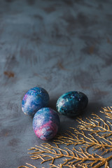  Easter holiday. Easter eggs with a golden branch on a blue surface.