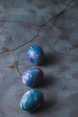 Easter holiday. Easter painted colorful eggs and branch on a blue background.