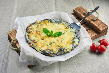 Baked pizza with 4 types of cheese, white sauce and on a black wooden background in a composition with ingredients. black cake. Close up