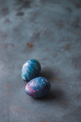 Easter holiday. Two Easter colorful eggs on a blue surface.