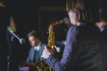 Concert view of a female saxophonist,  professional saxophone player with vocalist and musical...