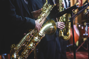 Concert view of a saxophonist, saxophone player with vocalist and musical during jazz band...