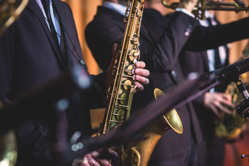 Concert view of a saxophonist, saxophone player with vocalist and musical during jazz band orchestra performing music on stage