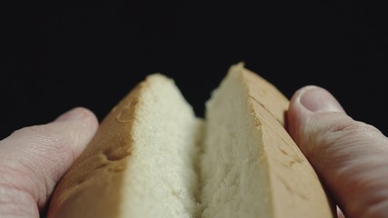 Man breaking white hot dog bread. Getting ready to cook. Close up.