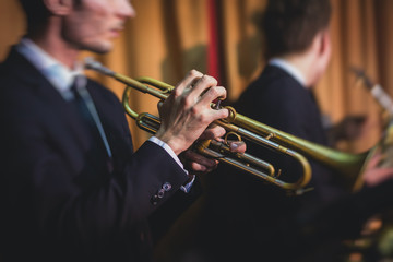 Concert view of a male trumpeter,  professional trumpet player with vocalist and musical during...