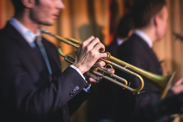 Concert view of a male trumpeter,  professional trumpet player with vocalist and musical during...