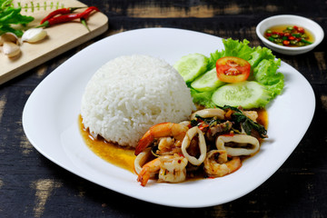 Rice topped with stir-fried pork, shrimp, squid and holy basil