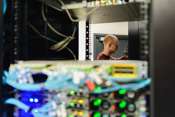 Man data center technician performing server maintenance