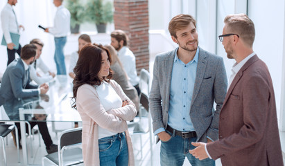 three young employees standing in a modern office.