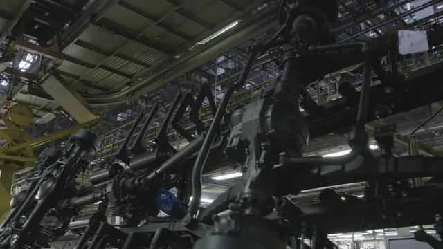 Production process of heavy mining trucks at the factory. Scene. Dump truck transmissionon the Industrial conveyor in the workshop of an automobile plant.