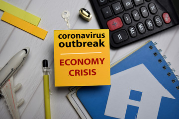 Coronavirus Outbreak and Economy crisis write on a sticky note isolated on Office Desk.