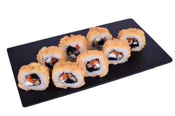 Traditional fresh japanese sushi on black stone Tokyo Warm Roll on a white background. Roll ingredients: salmon, philadelphia cheese, black tobik caviar, shiitaki mushrooms, nori, rice.