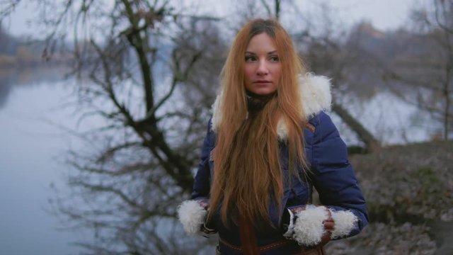 portrait of beautiful woman with long hair in autumn park with river