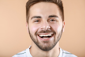 Obraz premium Handsome smiling young man on color background