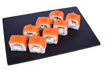 Traditional fresh japanese sushi rolls on black stone Philadelphia Ikura on a white background. Roll ingredients: salmon, philadelphia cheese, cucumber, red caviar, nori, rice.