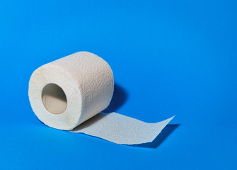 Expanded roll of white toilet paper on a blue background.