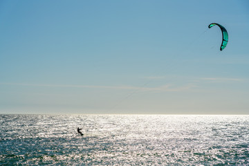 The athlete practices kate board surfing the sea on the waves. Summer in Portugal Algarve.