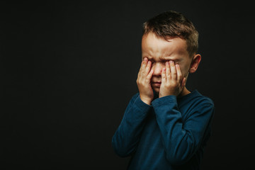 a child whose depression is on a black background with his hands closed