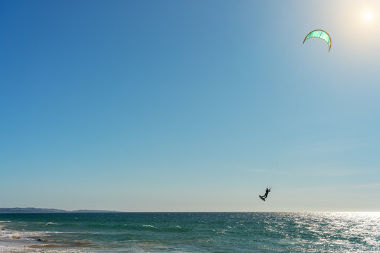The athlete practices kate board surfing the sea on the waves. Summer in Portugal Algarve.