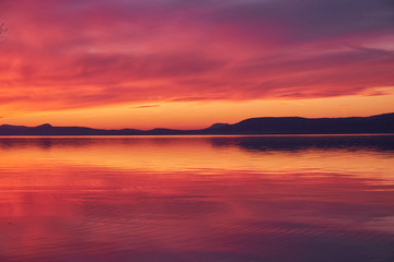 Fototapeta na wymiar landscape colorful sunset reflecting water and hills at lake Balaton, Hungary