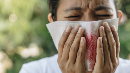 Close up Woman have a coughing up blood hands holding tissue paper 