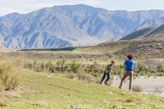 A man photographs the mountains of Altai, next to him is his son