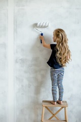 kid painting wall with roller