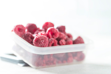 Frozen raspberry close up on a light background. Top view, copy space. Fresh organic berries macro
