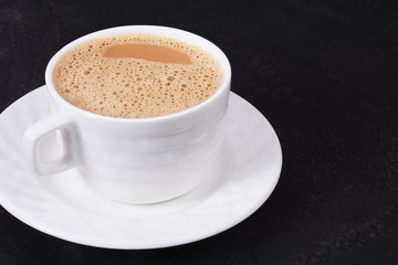 Cup of hot coffee on a black background