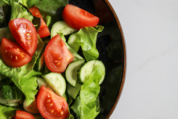 Summer fresh detox salad with tomatoes, cucumber, romaine lettuce and olive oil. Healthy diet food for vegan or vegetarian, top view, copy space