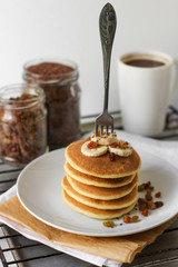 Pancakes with slices of banana. Fork is stuck in pancakes