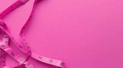 Pink centimeter on pink background. Simple flat lay with pastel texture. Fitness concept. Stock...