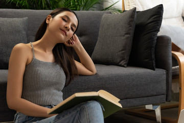 Obraz premium Asian women sit in relax room read book at home time in holiday.