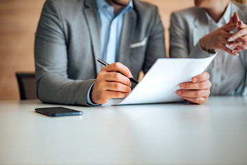 Close-up image of a man signing a document, copy space.