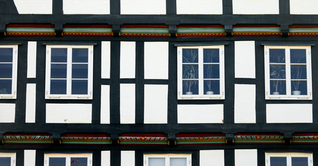 Section of a half-timbered house with black beams and built-in windows
