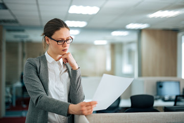 Concentrated manager at work, reading document, portrait.