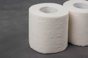 Two toilet paper rolls on a gray background