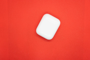 Wireless headphones in the charging box, air pods convenient contactless headphones, stylish color background