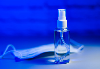Antiseptic and mask on a blue background. Stop pandemic. COVID-19 and coronavirus identification. Pandemic.