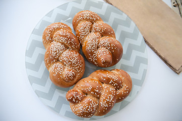 Challah or Hala is a traditional jewish sweet fresh sabbath bread loaf, fresh bun on cutting board.