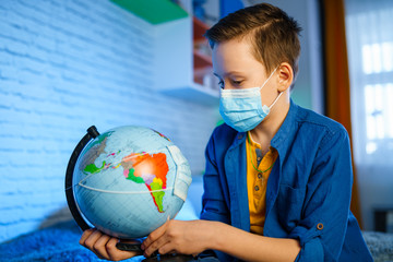 Earth globe in face mask in boy`s hands. Air and environment pollution. Save the planet concept.