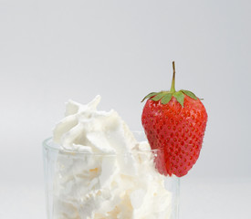Glass of fresh strawberry milkshake, smoothie and fresh strawberries on pink, white and wooden background. Healthy food and drink concept.