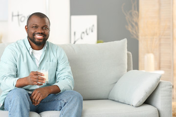 African-American man drinking milk at home