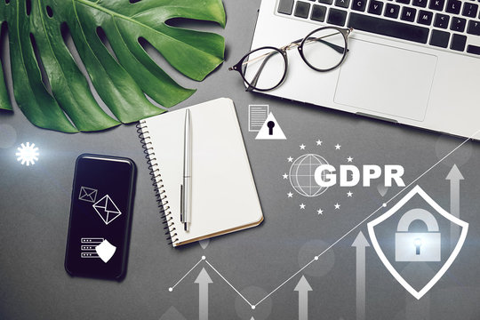 Cyber internet security concept. GDPR and cybersecurity. Top view of laptop, monstera leaves, notebook, smartphone, pen and eyeglasses on grey background. Social media, blog hero header template.