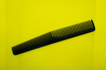 Black comb isolated on color background