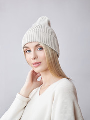 Blonde woman with long hair wearing a hat and a white sweater. Beauty portrait of a girl, natural cosmetics