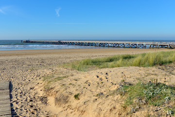 Fototapeta na wymiar Pier of Saint-Jean-de-Monts seen from dunes, a commune in the Vendée department in the Pays de la Loire region in western France.