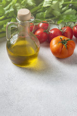 Mediterranean cuisine, fresh ripe tomatoes, olive oil, celery on gray background